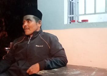 foto : Fathuri Rahman duduk di pos satpam depan kediaman Kyai Marwazi
