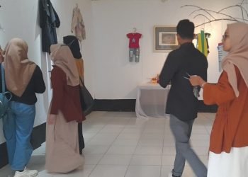 Para pengunjung melihat satu per satu karya korban kekerasan di gedung Teater Arena Taman Budaya Provinsi Jambi, Jumat sore (16/12). [Dok Hajrin Febrianto]