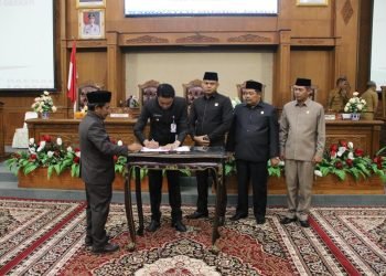 Pj Bupati Muarojambi, Bachyuni Deliansyah, didampigi Ketua DPRD Muarojambi menandatangani Ranperda Tentang Pengolahan Keuangan Daerah Muarojambi. (Foto RJ.COM/Deni)
