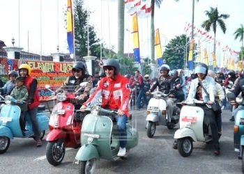 Pj Bupati Muaro Jambi Ikut mengendarai sepeda motor Vespa kesayangan nya saat Sunday Morning Side (Sunmori) bersama ratusan pecinta Vespa/scooterist dan para rider komunitas motor di Kota Jambi, Minggu (15/01/2023). (Dok. Diskominfo Muaro Jambi)