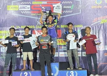 Adit Coco, joki drag race Kodijah Speed saat menerima tropi dari atas podium satu kelas Bracket Time 9. (Foto Sinsen)