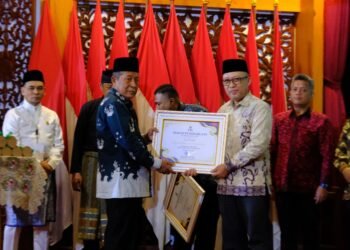 Wakil Gubernur Jambi Abdullah Sani menyerahkan piagam penghargaan kepada penerima Muzakki Konsisten dalam Rakorda BAZNAS Provinsi Jambi Tahun 2025 di Auditorium Rumah Dinas Gubernur Jambi, Senin (13/10/2025) (Dok. Erit - Kominfo)
