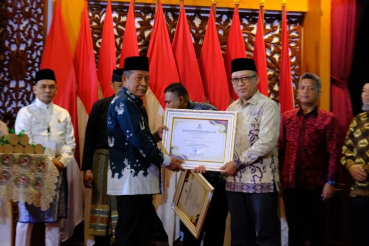 Wakil Gubernur Jambi Abdullah Sani menyerahkan piagam penghargaan kepada penerima Muzakki Konsisten dalam Rakorda BAZNAS Provinsi Jambi Tahun 2025 di Auditorium Rumah Dinas Gubernur Jambi, Senin (13/10/2025) (Dok. Erit - Kominfo)